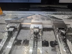 Aluminium component on CNC bed with coolant and chips