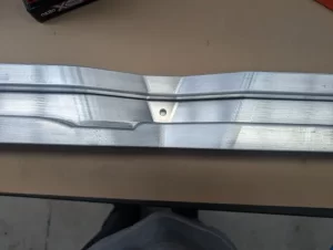 Angled view of a milled aluminium part with fine finish