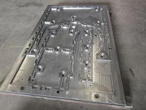 Angled view of CNC machined metal plate with toolpaths