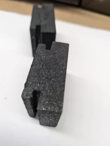 Close up of angled black blocks showing machined grooves