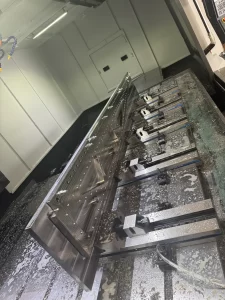 Close-up of large precision machined metal part on CNC bed