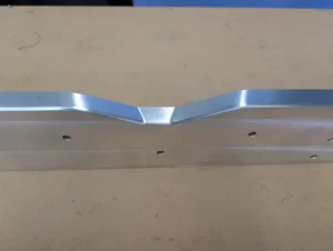 Close up of machined aluminium part with a v shaped curve