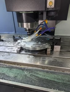 CNC machine drilling aluminium disc with coolant flow