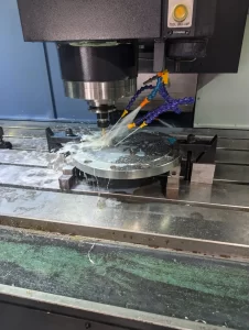 CNC machine drilling metal part with coolant