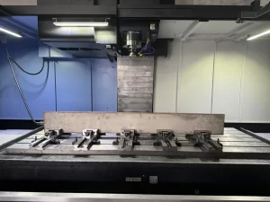 CNC machine with metal workpiece clamped on bed