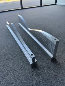 CNC machined aluminium parts shown at an angle on floor
