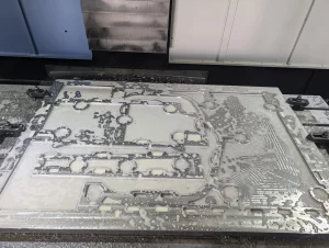 CNC machined aluminium plate covered with coolant during milling