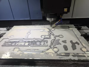 CNC milling in progress with tool cutting through aluminium and coolant flow