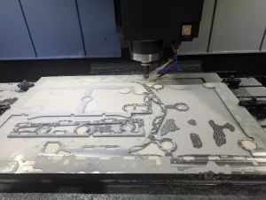 CNC tool head cutting detailed patterns in a metal sheet