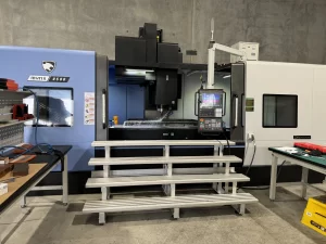 Front view of installed CNC machine with access stairs and workstations