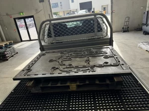 Large machined plate being transported on a pickup tray