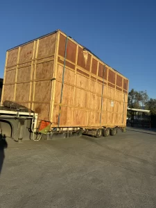 Large wooden crate loaded on a flatbed trailer for transport