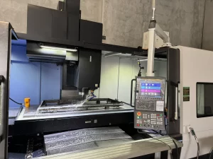 Side view of CNC machine in action with control panel and coolant