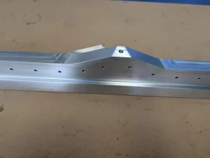 Sloped-edge aluminium component with multiple small drilled holes