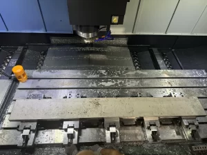 Top view of CNC machine bed with clamped workpiece