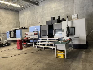 Wide shot of CNC workshop with multiple machines and tools