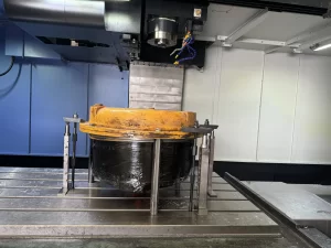 Yellow industrial part clamped in a CNC machine